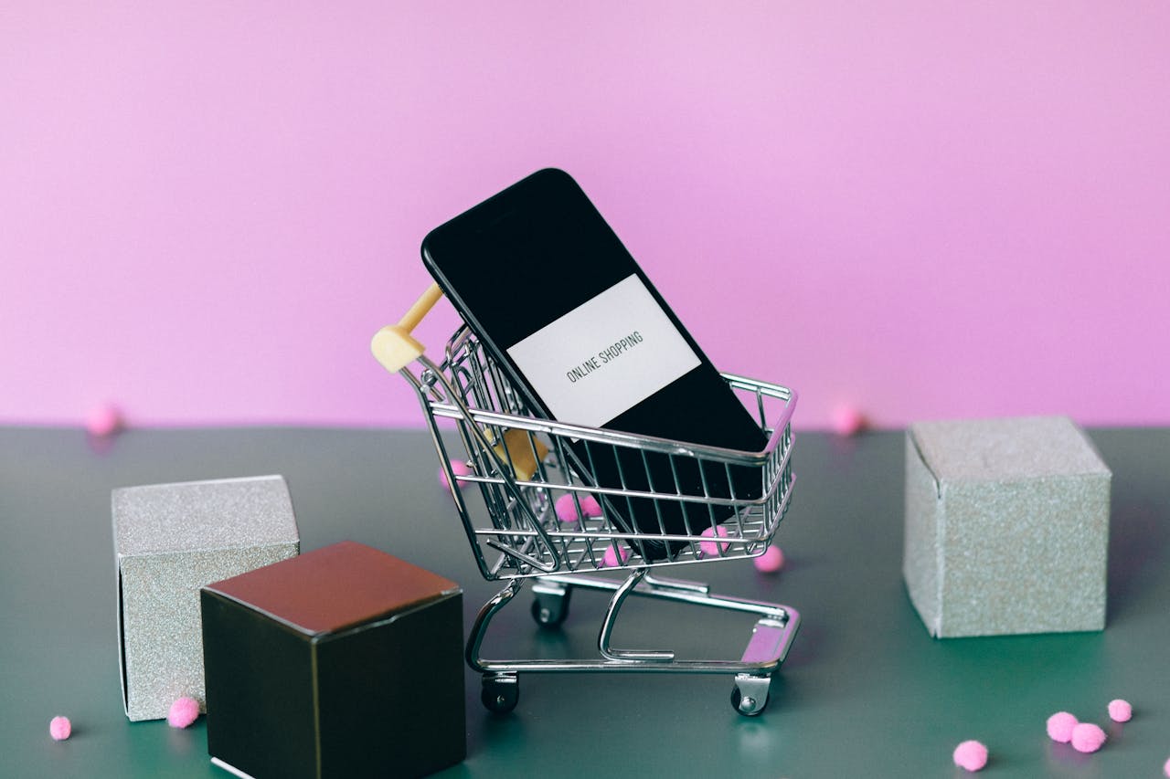 Home A smartphone with a shopping cart depicting the concept of online shopping in a colorful studio setup.